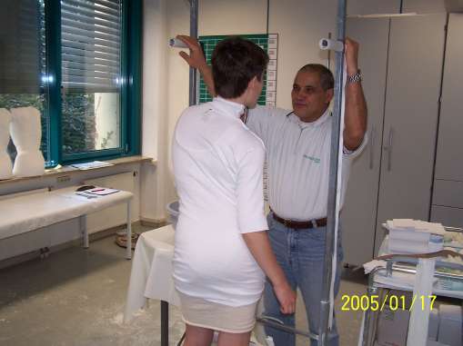 Meister Rahmouni bei der Instruktion einer Patientin vor dem Gipsabdruck wie sie sich im Gipsrahmen zu halten hat.